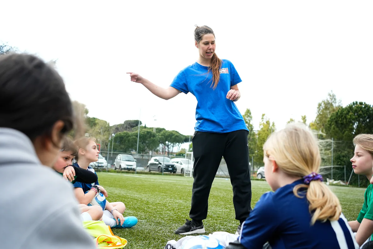 Tecnico di calcio mentre parla alle allieve